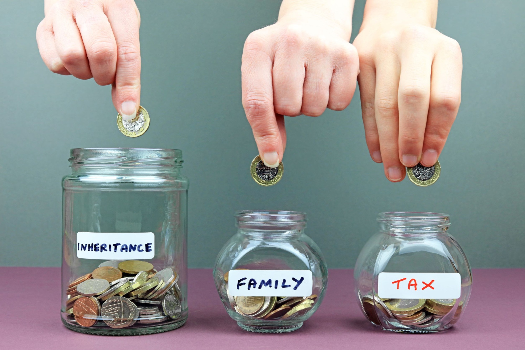 This image of three jars containing coins illustrates how an inheritance maty be divided between tax due to HMRC and family