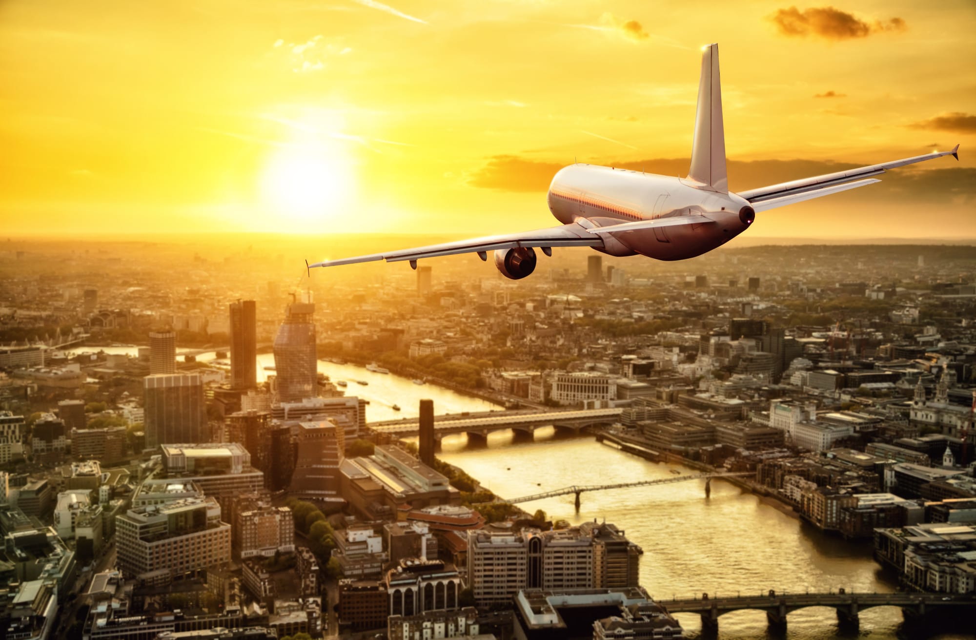 Relocating to the UK: this image shows a plane flying along the River Thames in London