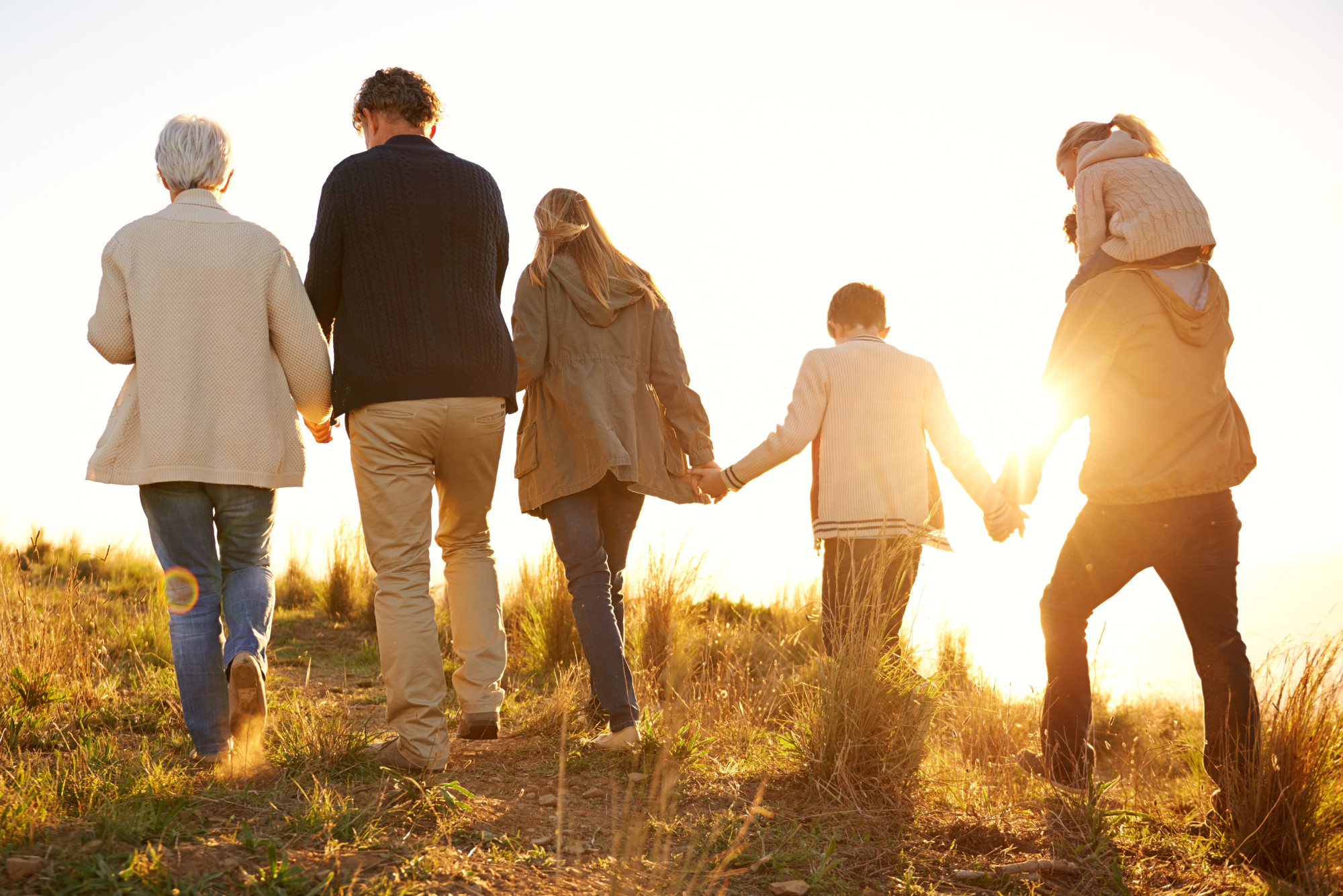 How will the Autumn Budget 2024 impact your investments and family? In this image, three generations of a family walk in the countryside in the early evening