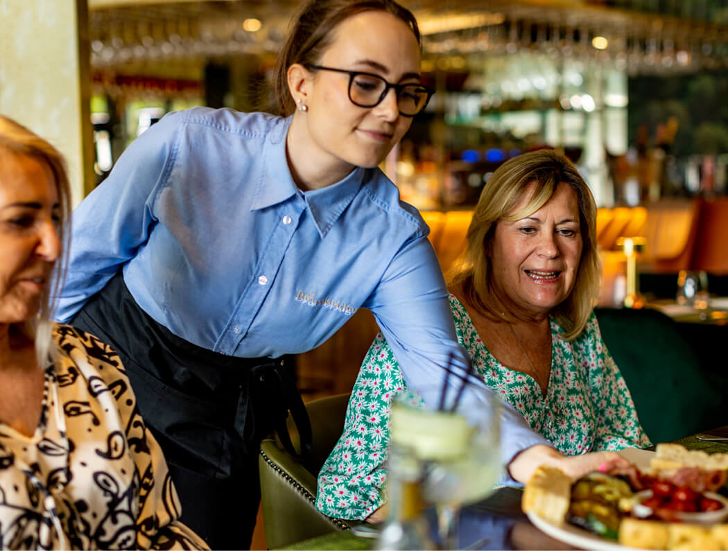 waitress serving food to two women