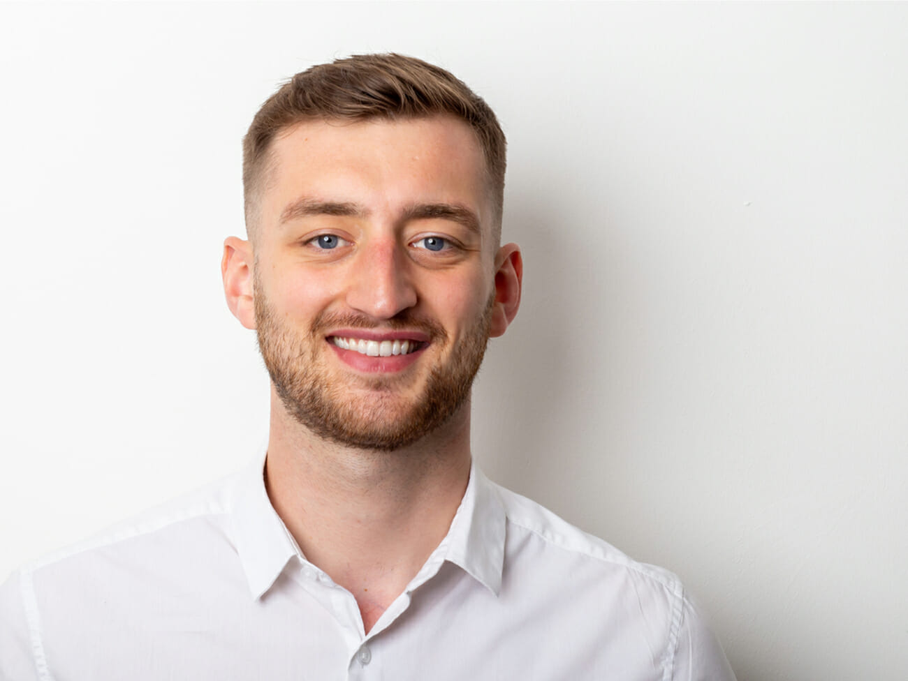 man with white shirt smiling to camera